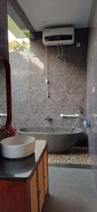 a bathroom with a bath tub and a sink at The Green Sidemen in Silebeng