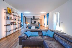 una sala de estar con un sofá de cuero marrón con almohadas azules en Villa Opulentia piscine vista mare, en Plemmirio