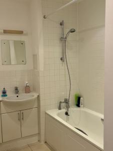 Un baño con lavabo, bañera y ducha. en 1 Bedroom Flat near Excel, O2, Canary Wharf - London, en Londres