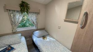 レネッセにあるChalet JT08 in Renesseのベッドが2つと窓がある小さな部屋
