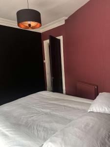 a bedroom with a white bed and a black wall at Murray Apartment in Inverness +1 photo