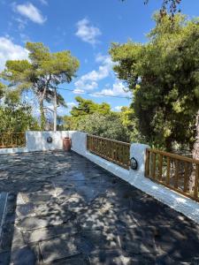 a stone walkway with a fence and trees at Villa Anna in Kalamos