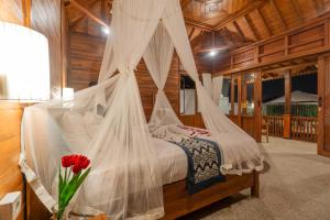 a bedroom with a bed with mosquito netting at Pondok di Uma Villa Ubud in Ubud