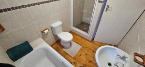 a bathroom with a toilet and a tub and a sink at Mountain View in Klein Brak Rivier +5 photos
