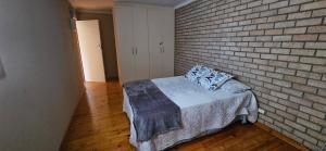 a room with a bed and a brick wall at Mountain View in Klein Brak Rivier