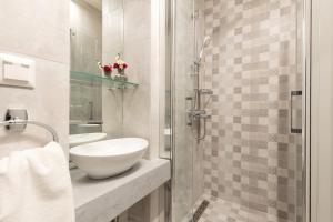 a bathroom with a sink and a shower at Petite Town Hall Apartment by Konnect, Old Corfu Town in Corfu Town +2 photos