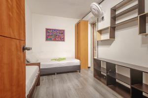 a small room with two beds and a closet at Hostal Machu Picchu Medellín in Estación El Salto