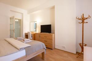 a bedroom with a bed and a tv on a dresser at St. Hubert House in Prague
