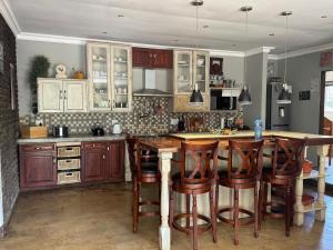 Eine Küche mit Holzschränken und einer Kochinsel mit Barhockern in der Unterkunft At Harmony in Germiston