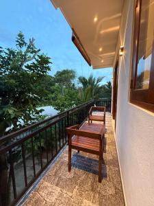 a bench on the balcony of a house at The Green Loft Rooms in Ahangama