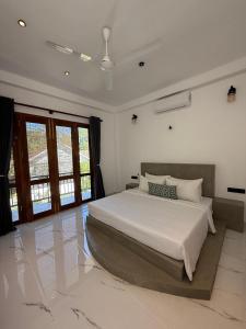 a bedroom with a large bed in a room with windows at The Green Loft Rooms in Ahangama