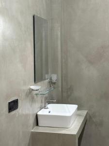 a bathroom with a white sink and a mirror at The Green Loft Rooms in Ahangama