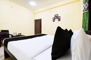 a bedroom with a white bed with black pillows at Hotel O HIGHWAY STAY IN in Bandha Chhada