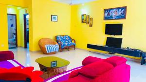 a living room with a red couch and a tv at 3bhk Villa calangute in Calangute