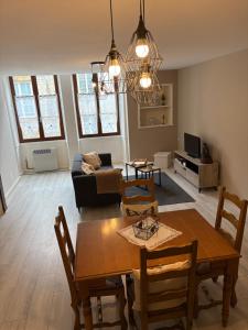 a living room with a table and a couch at Appartement centre ville in Langres