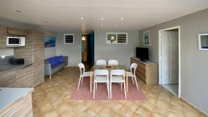 Una cocina y un comedor con mesa y sillas. en Ti Paradi, villa 12 pers, 2 piscines, vue golf mer, en Les Trois-Îlets