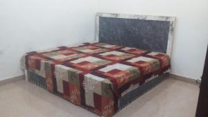 a pile of blankets sitting on a bed in a room at Radha Rani Dham in Rādha Kund