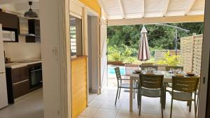 Quartiers Anse à lʼÂneにあるLAKAYOU, 4 pers, piscine privee, plageのテーブルと椅子のあるキッチンとダイニングルーム