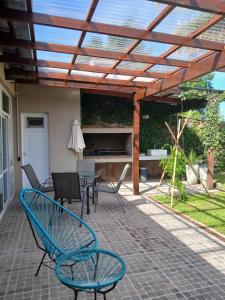 a patio with a wooden pergola with chairs and a table at La Casa de Alvear - Casco Histórico in San Antonio de Areco