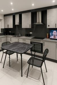 a kitchen with a table and chairs in it at Modern Luxury Rooms in Hillingdon