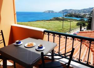 una mesa con un plato de comida y vistas al océano en Psaromoura Residence, en Agia Pelagia
