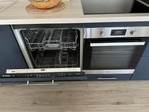 an oven with its door open in a kitchen at Maisonnette Migahome in Crecy la Chapelle +49 photos