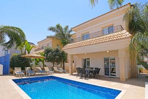 a villa with a swimming pool and a house at Villa Angelina - 300m from Kapparis beach in Paralimni