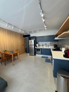 a large kitchen with a table and a refrigerator at Refúgio da Lagoa azul in Angra dos Reis