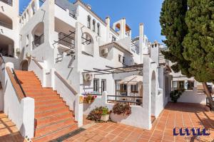 een groot wit gebouw met trappen en planten bij 2 BR Beach and Pool By Better Bookings in Arroyo de la Miel