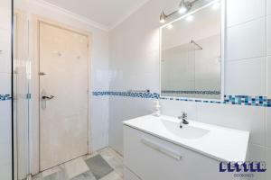 een witte badkamer met een wastafel en een douche bij 2 BR Beach and Pool By Better Bookings in Arroyo de la Miel