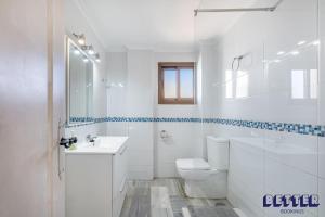 een witte badkamer met een toilet en een wastafel bij 2 BR Beach and Pool By Better Bookings in Arroyo de la Miel +14 foto's