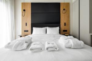 a white bed with two towels on top of it at HAYASHI Boutique Apartments in Sofia