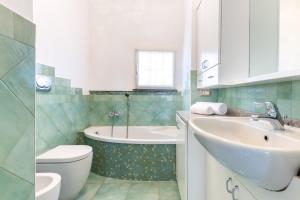 ein Badezimmer mit Badewanne, Waschbecken und Toilette in der Unterkunft Hostdomus-Villa Verde in Noli