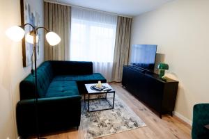 a living room with a green couch and a table at Apartamenty EUROPA in Jasło