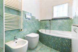ein Badezimmer mit Badewanne, Toilette und Waschbecken in der Unterkunft Hostdomus-Villa Verde in Noli