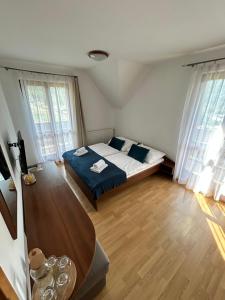 a bedroom with a bed with blue sheets and two windows at Resort Levočská Dolina in Levoča +59 photos