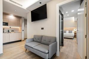a living room with a couch and a tv on a wall at Dobo Madrid Ricardos in Madrid