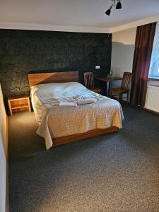 une chambre avec un lit, une table et des chaises dans l'établissement "Zacisze", à Zgierz