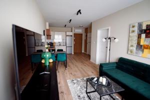 a living room with a green couch and a table at Apartamenty EUROPA in Jasło +14 photos
