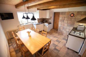 a kitchen with a wooden table and a dining room at Chalupa u Hejsků in Jilem
