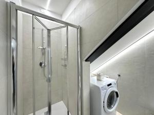 y baño con ducha y lavadora. en Ca' D'Agostino, en Battaglia Terme
