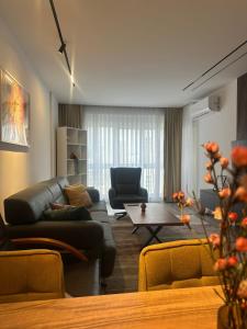 a living room with a couch and a table at Aparte - Emshir in Pristina