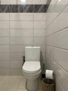 a white bathroom with a toilet and a tub at Aparte - Emshir in Prishtinë +18 photos