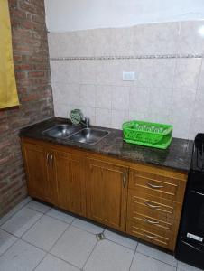 un comptoir de cuisine avec un évier et un sac vert dessus dans l'établissement CASA EL GRINGO ubicada en Villa Parque Siquiman con vista al río tres habitaciones y capacidad para ocho personas, à Villa Parque Siquiman