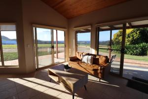 sala de estar con sofá, mesa y ventanas en Summergrove Estate, en Carool 2 fotos más