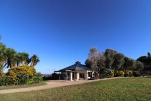 una casa en un parque con palmeras y un campo en Summergrove Estate, en Carool