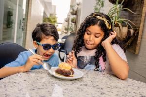 two young children sitting at a table eating food at Go Inn Hotel Aracaju in Aracaju