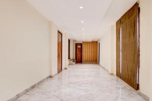 a corridor of a building with white walls and wooden doors at Collection O Dehradun Central Formerly Hotel Orange Residency in Dehradun