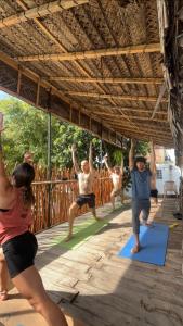 un grupo de personas haciendo yoga en una terraza en One More Day Hostel, en Weligama