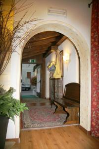 a hallway with an archway with a piano in it at Albergo Garnì Cavento in Pinzolo